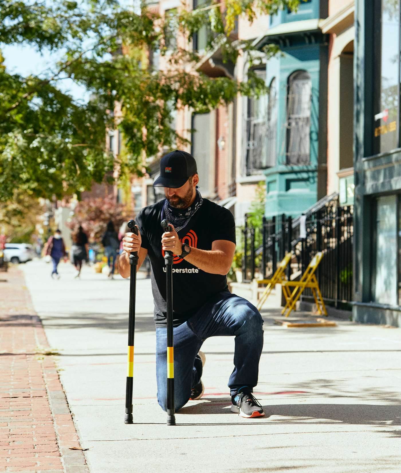 Photo of person kneeling using Upperstate poles to help balance.